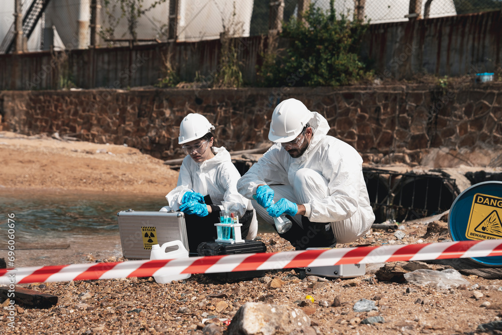 Scientist wear protection suit checking chemical and water analysis and water quality from factory. Protecting Against Hazards and Contamination. Scientist wear protection suit checking chemical and water analysis and water quality from factory. Protecting Against Hazards and Contamination.