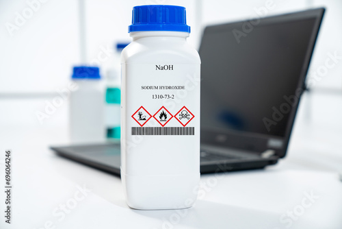 NaOH sodium hydroxide CAS 1310-73-2 chemical substance in white plastic laboratory packaging photo