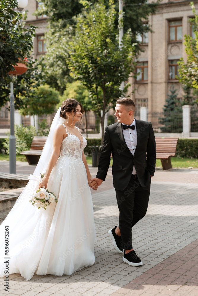 the groom in a brown suit and the bride in a white dress the groom in a brown suit and the bride in a white dress