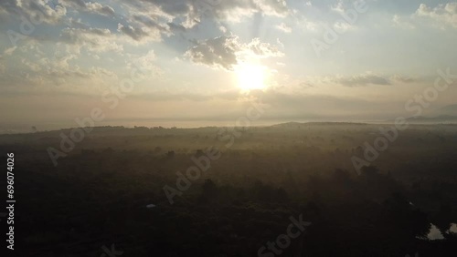 Aerial view of eastern morning sunrise, green fields and blue sky with white clouds and morning mist.