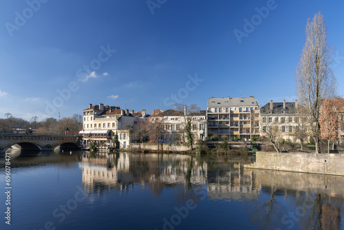 Metz, France - January 19th 2019 : View on the buildings along the Moselle river with reflections on the water, in the historical part of the city.
