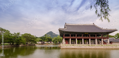 Gyeongbokgung Palace during cloudy summer day. Korean text translated to English means Gyeonghoeru, which is name of pavillion.
