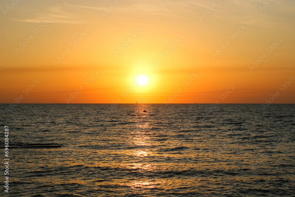 Sun rising over the sea. Orange sunrise. Sea surface
