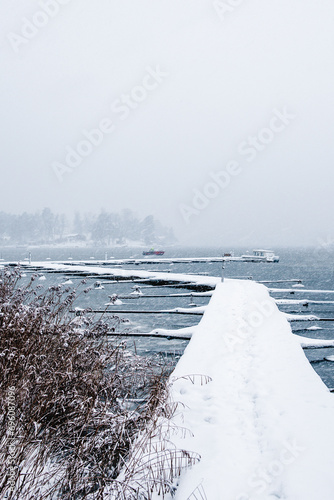 Landscape. Boat pier in winter. A wonderful winter view of the frozen lake.