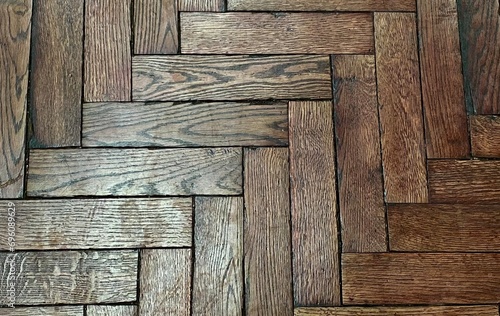 Old parquet floor close-up, top view. Paint and varnish are peeling off the wooden planks. View from above. 