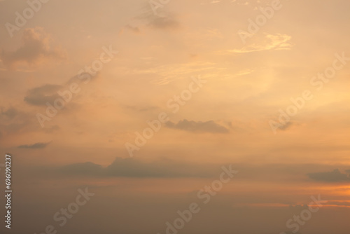 Warm foggy sunset sky with pastel romantic clouds, last rays of sun on the horizon before sunset