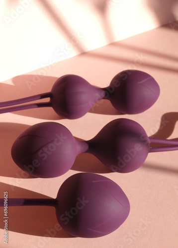 Purple kegel balls in a soft pink background / Vaginal balls sex toy concept. Geisha balls pelvic floor healthcare / Ben wa balls feminine concept.  photo
