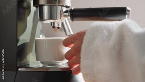 Lady brews beverage with coffee machine photo