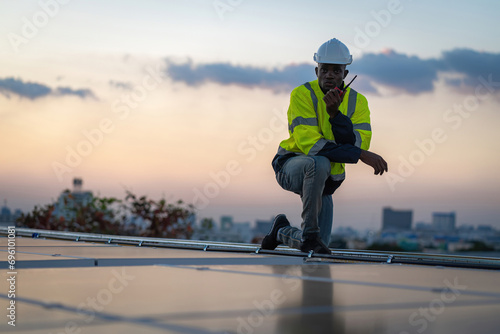 Engineer service check installation solar cell on the roof of factory. Engineers walking on roof inspect and check solar cell panel. Engineer working inspection installation solar cell on the roof