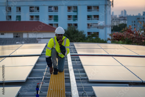 Technician working on ecological solar farm. Renewable clean energy technology concept. Specialist engineer control drone checking top view of installing solar roof panel on the factory rooftop