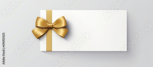 Blank white gift voucher with gold ribbon isolated on white photo