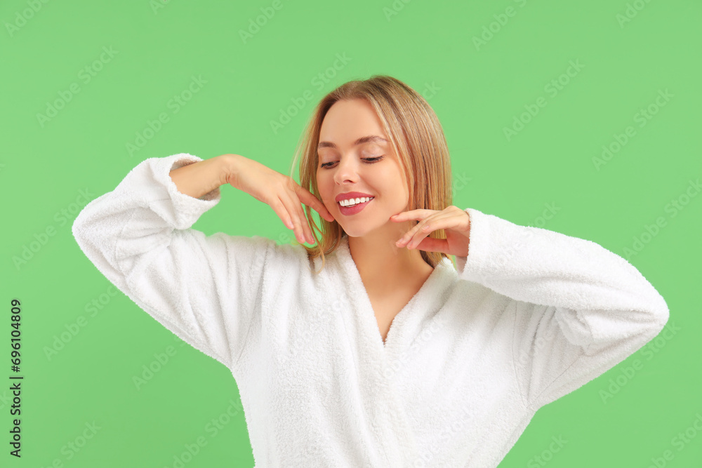 Pretty young woman in bathrobe on green background. Skin care concept Pretty young woman in bathrobe on green background. Skin care concept