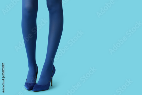 Legs of beautiful young woman in stylish high heels on blue background