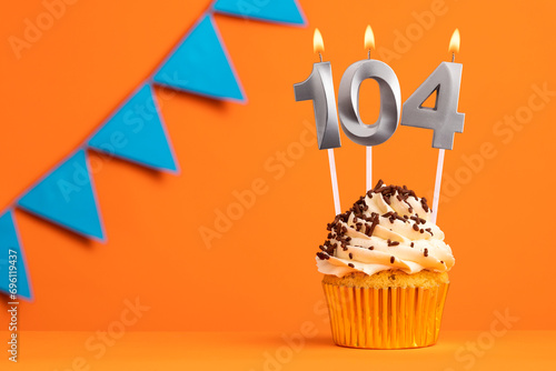 Candle number 104 - Cake birthday in orange background