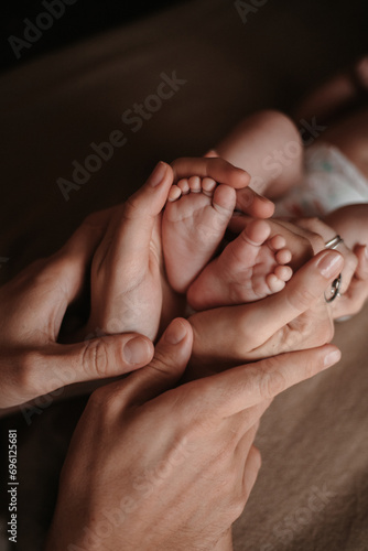 parents' hands in the shape of a heart hold a child