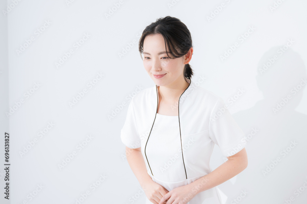 Young female nurse in white nurse's uniform, beauty, medical, etc., upper body on white background bowing at an angle