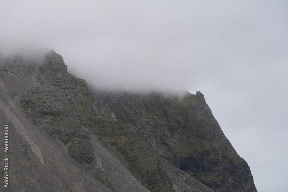 Barren Mountains of rock standing tall with clouds on the top 