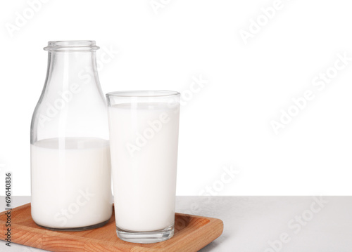 Glassware with tasty milk on light table against white background