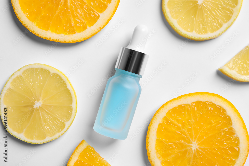 Bottle of cosmetic serum and sliced citrus fruits on white background, flat lay Bottle of cosmetic serum and sliced citrus fruits on white background, flat lay