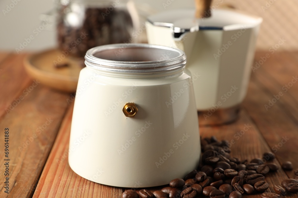 Obraz premium Moka pot and coffee beans on wooden table, closeup