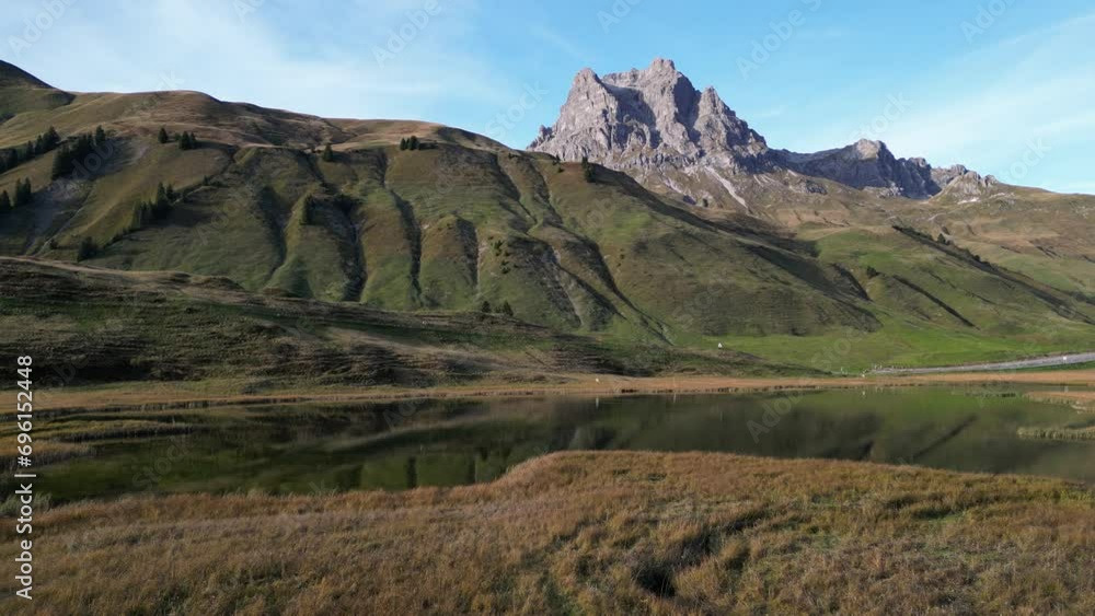 Zoom in shot of a grassland with high mountain summits and water puddle in the middle of the frame Zoom in shot of a grassland with high mountain summits and water puddle in the middle of the frame