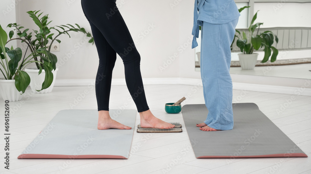 Caucasian woman stands on sadhu boards with therapist support. Caucasian woman stands on sadhu boards with therapist support.