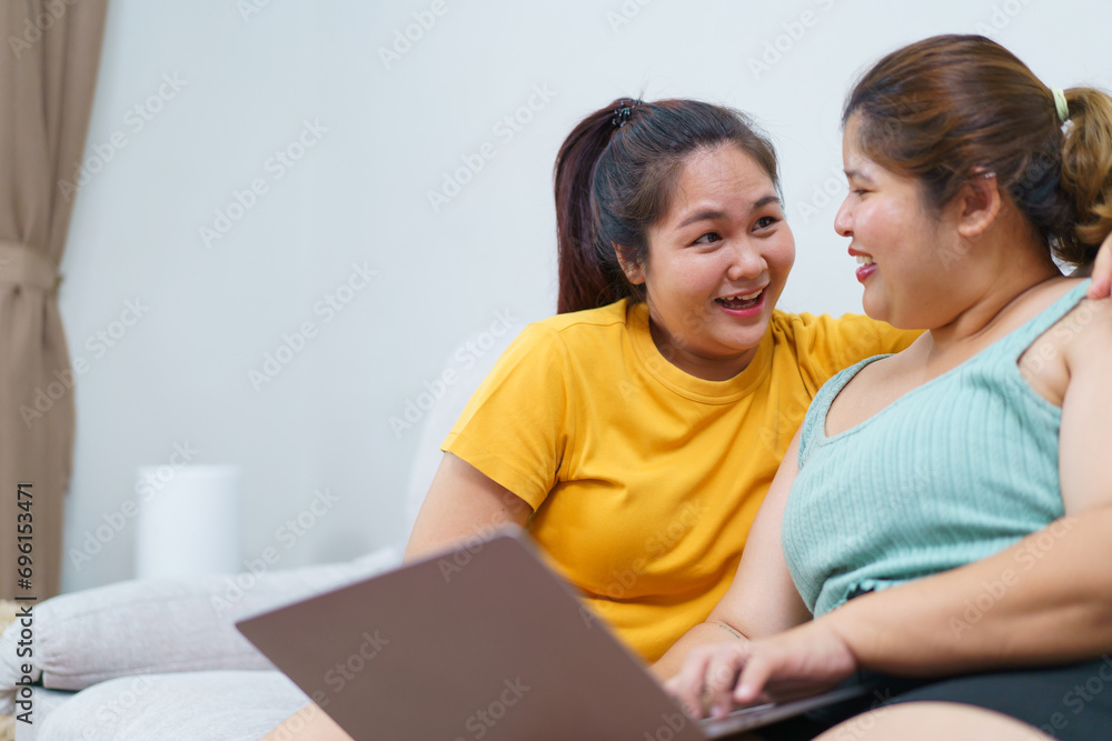 Happy Asian women friend relaxing in living room and drink a cup of tea together. Happy Asian women friend relaxing in living room and drink a cup of tea together.