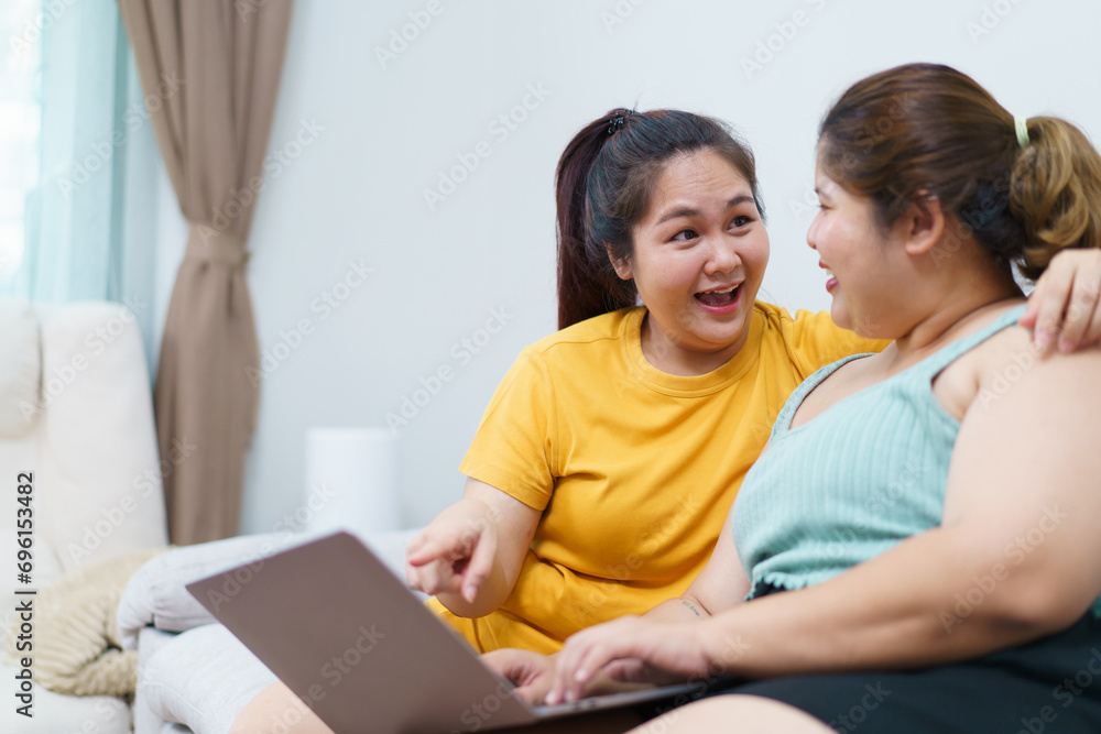 Happy Asian women friend relaxing in living room and drink a cup of tea together. Happy Asian women friend relaxing in living room and drink a cup of tea together.