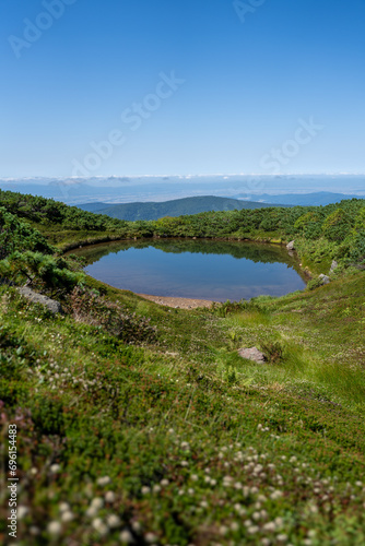 Fototapeta Naklejka Na Ścianę i Meble -  clear ponds reflecting the sky above three tree line on mount asahidake