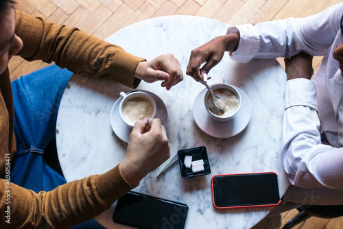 Overhead shot of two people on a date drinking coffee photo