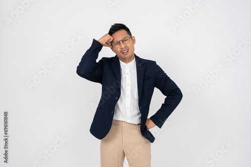Foto A doubtful, confused Asian businessman is standing on an isolated studio white background