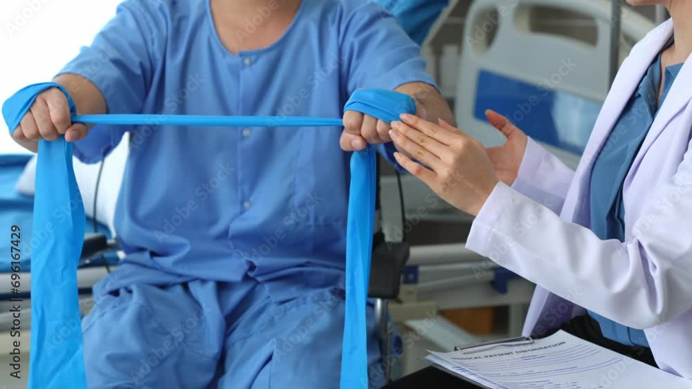 A physical therapist gives resistance band exercises. About the arms and shoulders of male office workers, office syndrome, and male patients. Physiotherapy concept. A physical therapist gives resistance band exercises. About the arms and shoulders of male office workers, office syndrome, and male patients. Physiotherapy concept.