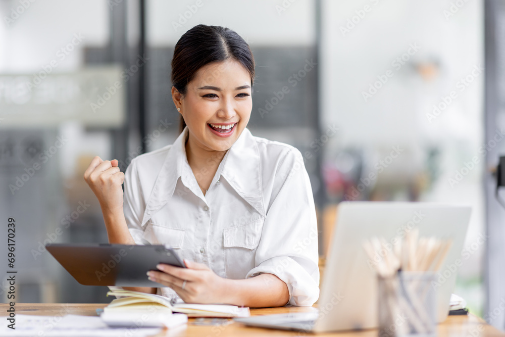 Young happy business asian woman working with tablet in corporate office
Young happy business asian woman working with tablet in corporate office