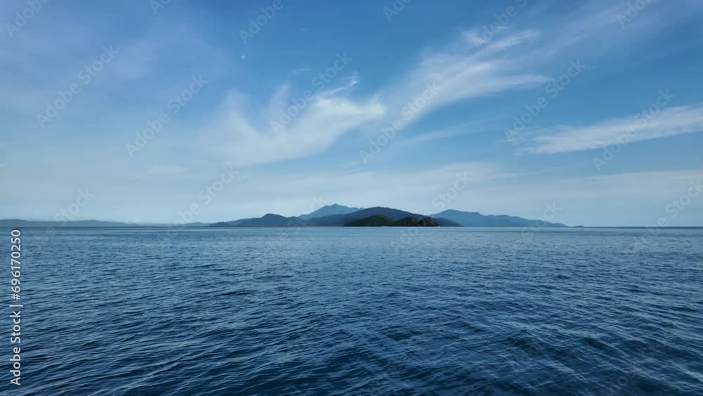 Fast moving boat view of Snapper Island and the Daintree Rainforest in the distance. Port Douglas Queensland Australia Fast moving boat view of Snapper Island and the Daintree Rainforest in the distance. Port Douglas Queensland Australia