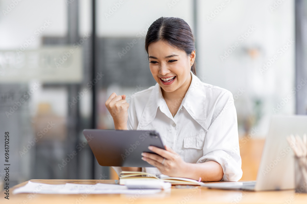 Young happy business asian woman working with tablet in corporate office
Young happy business asian woman working with tablet in corporate office