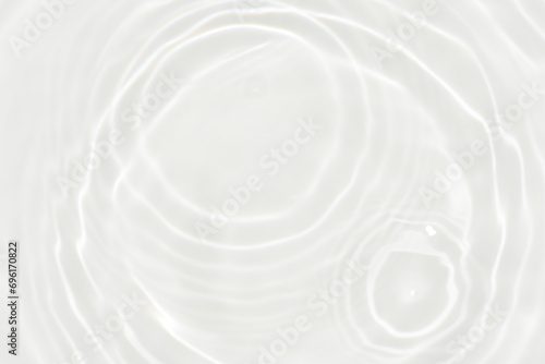 White water with ripples on the surface. Defocus blurred transparent white colored clear calm water surface texture with splashes and bubbles. Water waves with shining pattern texture background.