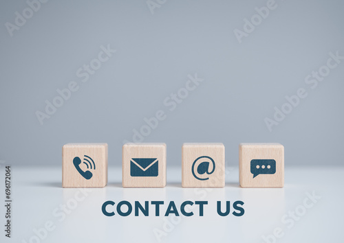 Contact us or Customer support hotline, people connect. Wooden cube blocks with telephone, e-mail, website address, and live chat icons. Customer care contact service, helpdesk advi photo