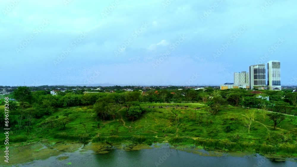 Aerial view of small pond surrounded by trees on the hills in Surabaya, Indonesia. Drone footage. Aerial view of small pond surrounded by trees on the hills in Surabaya, Indonesia. Drone footage.