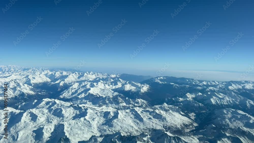 Alpine snowy landscape shot from an airplane, as seen by the pilots while flying at 8000m high in a spectacular winter day. Apilot’s perspective. Alpine snowy landscape shot from an airplane, as seen by the pilots while flying at 8000m high in a spectacular winter day. Apilot’s perspective.