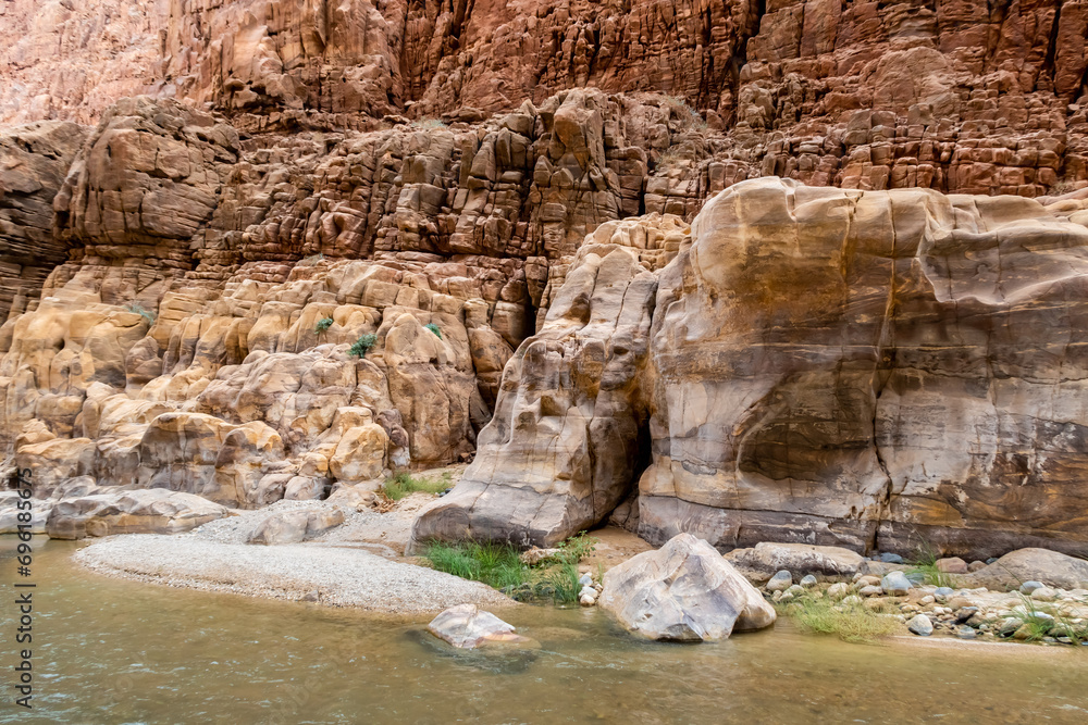 Diversity of colors of mountain rocks at the beginning of the tourist route in the Mujib River Canyon in Wadi Al Mujib in Jordan Diversity of colors of mountain rocks at the beginning of the tourist route in the Mujib River Canyon in Wadi Al Mujib in Jordan