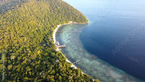 Scenic aerial view of remote tropical Kri Island covering in rainforest trees in Raja Ampat, West Papua, Indonesia