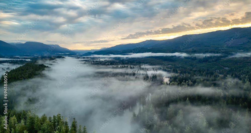 Valley by Mountains and Green Trees covered in fog. Canadian Landscape Nature Aerial