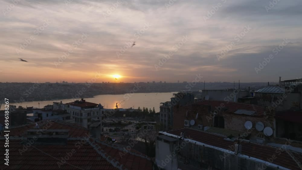 Forwards fly over apartment buildings. Revealing panoramic view of city and water surface against color sunset sky. Istanbul, Turkey Forwards fly over apartment buildings. Revealing panoramic view of city and water surface against color sunset sky. Istanbul, Turkey