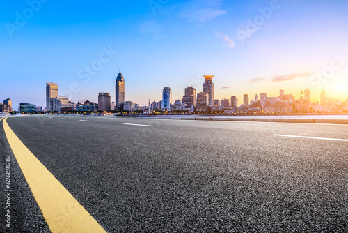 Highway road and city skyline with modern buildings at sunset in Shanghai, China.