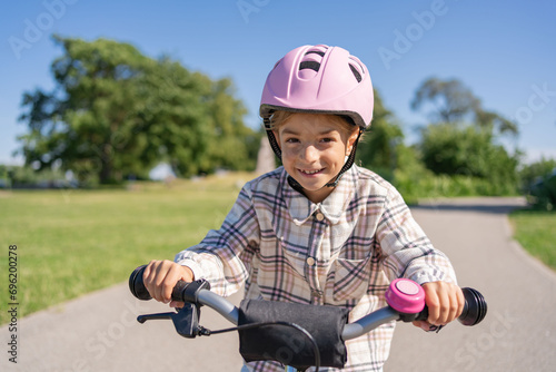 Cheerful child rides on a Bicycle in city park outdoor. 