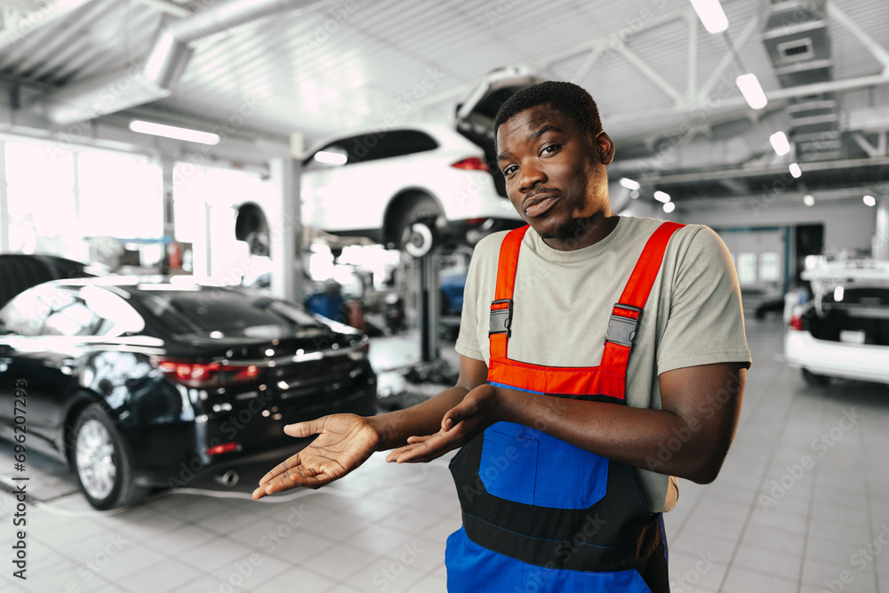 African man mechanic in uniform at the car repair station, portrait African man mechanic in uniform at the car repair station, portrait