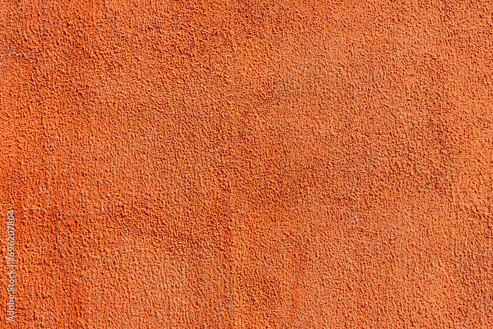 Fototapeta premium Close-up at orange pastel roughly concrete wall with cracked line on surface. Background and texture photo.