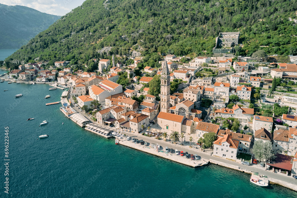 Aerial view of the ancient bell tower of the Church of St. Nicholas among the red roofs of houses. Perast, Montenegro