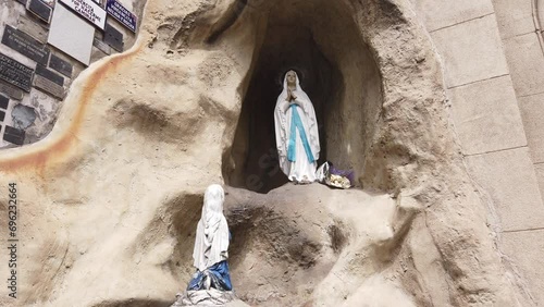 Statue of Virgin Mary Praying in a Cave at Lourdes Church Buenos Aires Argentina photo
