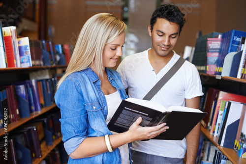 Teamwork, book or students reading in a library at university, college or school campus for education. Bookshelf, learning or young people with scholarship studying knowledge, research or information